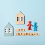 Home insurance message and wooden houses over blue background